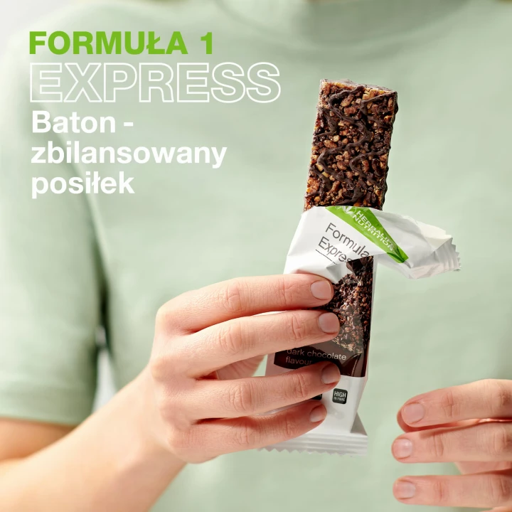 Kobieta trzyma Batona zbilansowany posiłek na zielonym tle.jpg